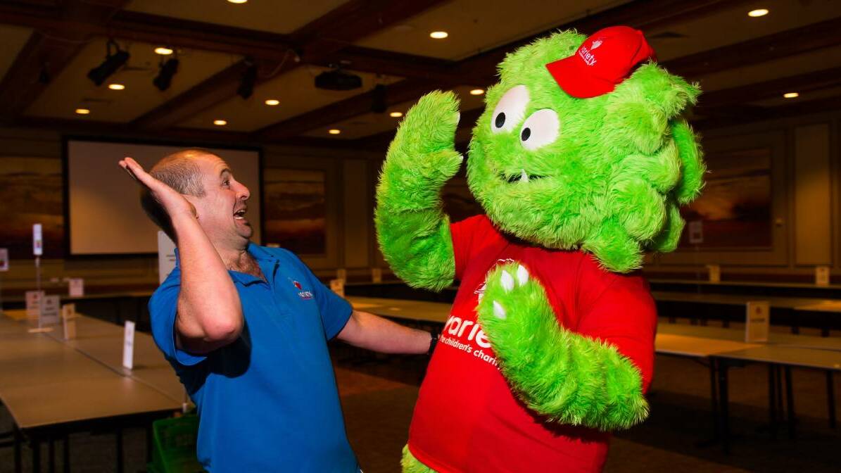 Variety state manager Luke Doyle and the Book Monster high-five at the Country Club. Picture: Scott Gelston