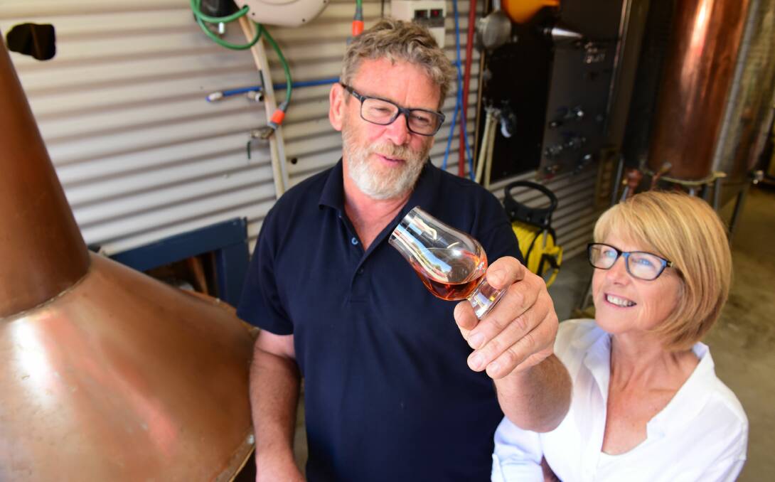 LIQUID GOLD: Mathew and Julie Cooper admire a sample of their product. Their company, Fannys Bay Distillery at Lulworth, is preparing to bottle its first barrels in March. Picture: Paul Scambler