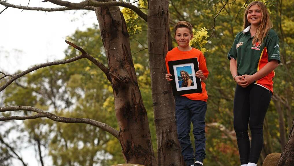Bella Dyer, 13, and Codey Ketchell, 12, with a photo of Codey's sister Tahlia Ketchell who died last year. Picture: Scott Gelston