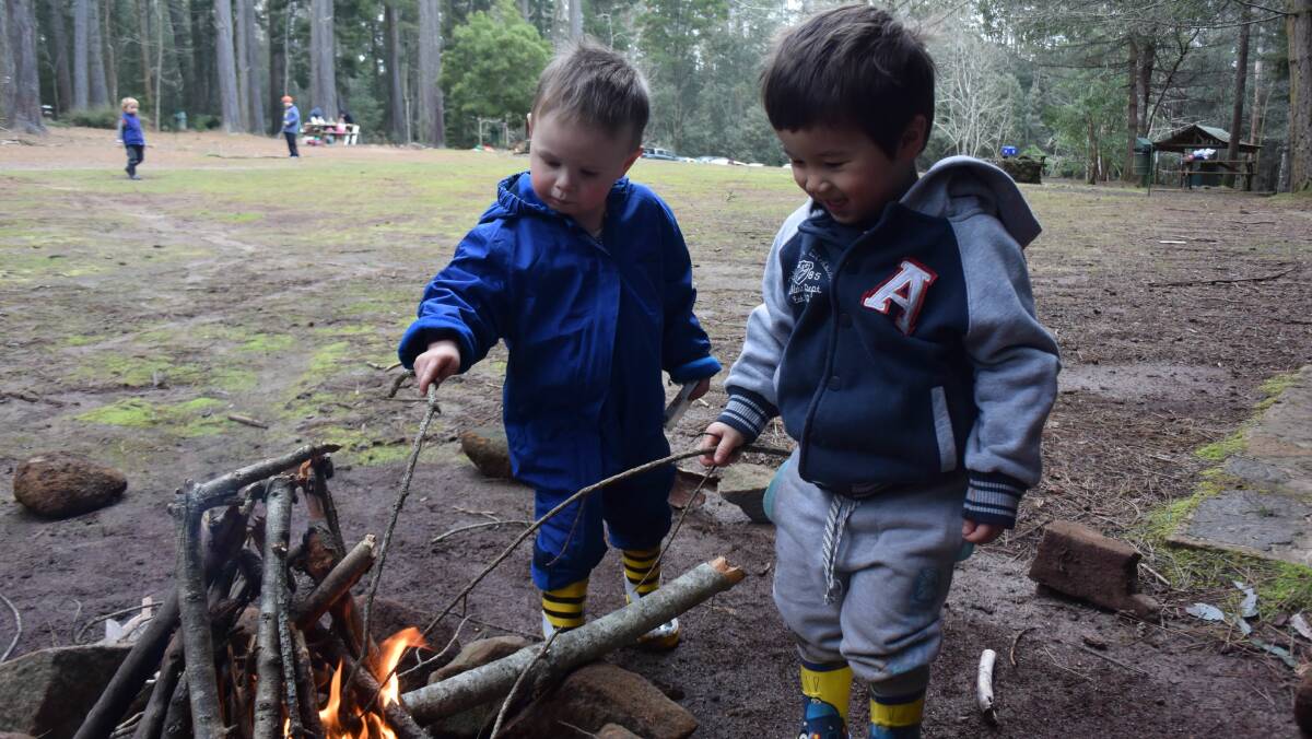 Toby Goss and Oberon Willard, both 2, learn around the fire at Playgroup Tasmania's @ Play with Nature at Hollybank. Picture: Michelle Wisbey