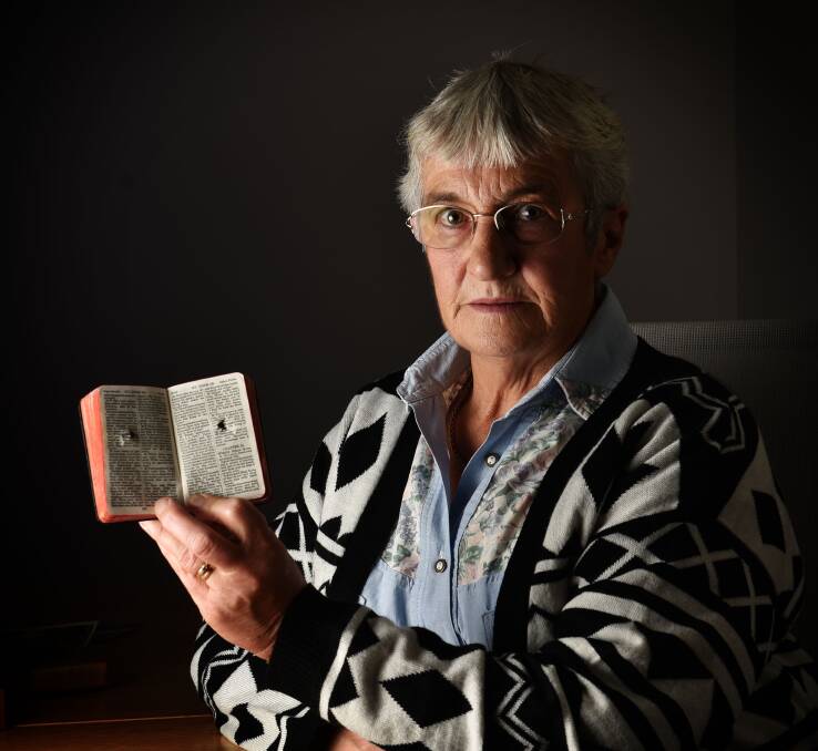 Relic: Anne Colgrave, of York Town, holds her great-uncle Percy Pinner's Bible. Percy was killed by a bullet that passed through his Bible into his chest, while Roy, the youngest brother, returned home. Picture: Scott Gelston.