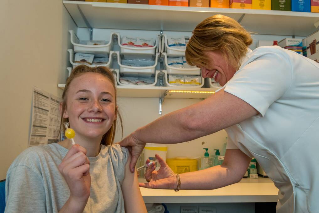 Pharmacist Tara Fox administers a flu vaccination to Loganne Fox, 13, at the Terry White pharmacy at Prospect Vale. Picture: Phillip Biggs