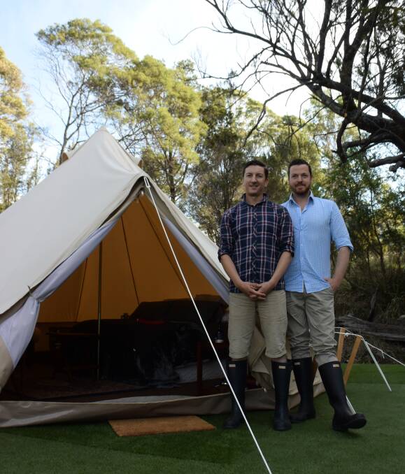 Glamping: Graham Kington and Nathaniel Wicks stand outside one of their glamping tents with a queen-size bed and heater inside. Picture: Alexandra Humphries.