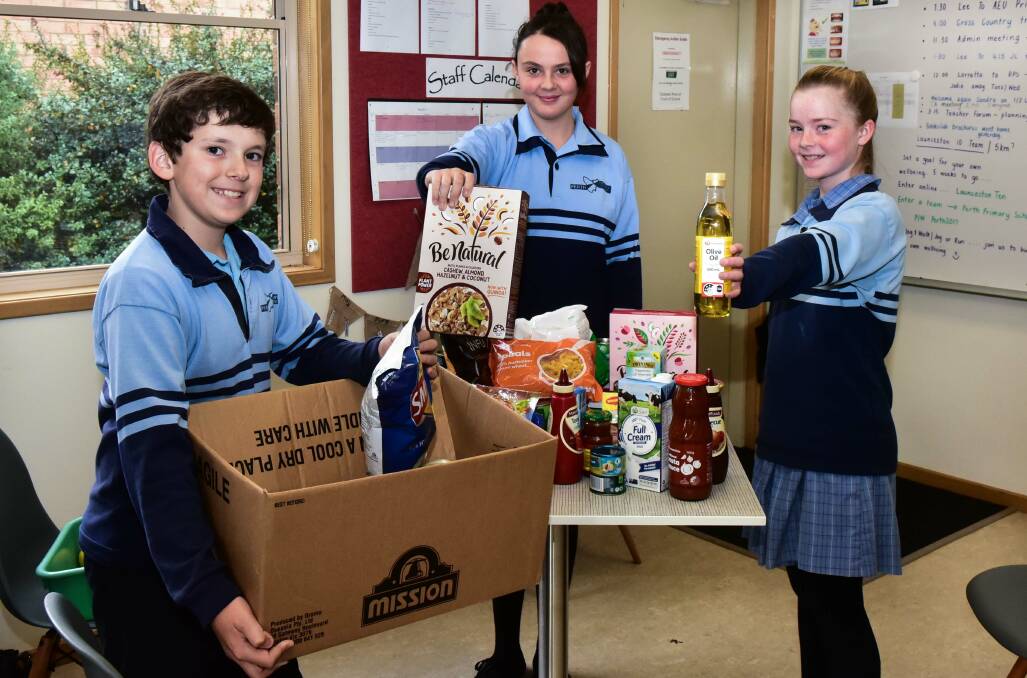 DONATE: Perth Primary School students Thomas Cooper, Maddie Davey and Poppy Hallam with some of the school's collection for Mission Possible. Photo: Neil Richardson 