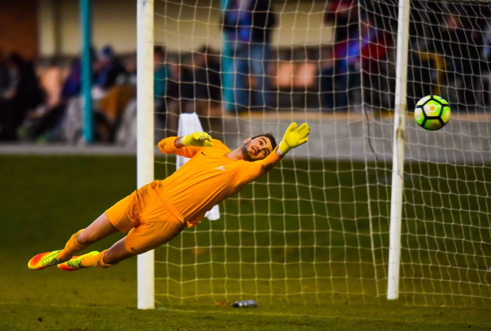 FULLY STRETCHED: Rangers goalkeeper Sam Whatman makes a diving save on Saturday in a desperate effort to keep his side in the home encounter against South Hobart at the NTCA No.2 Ground. Picture: Scott Gelston