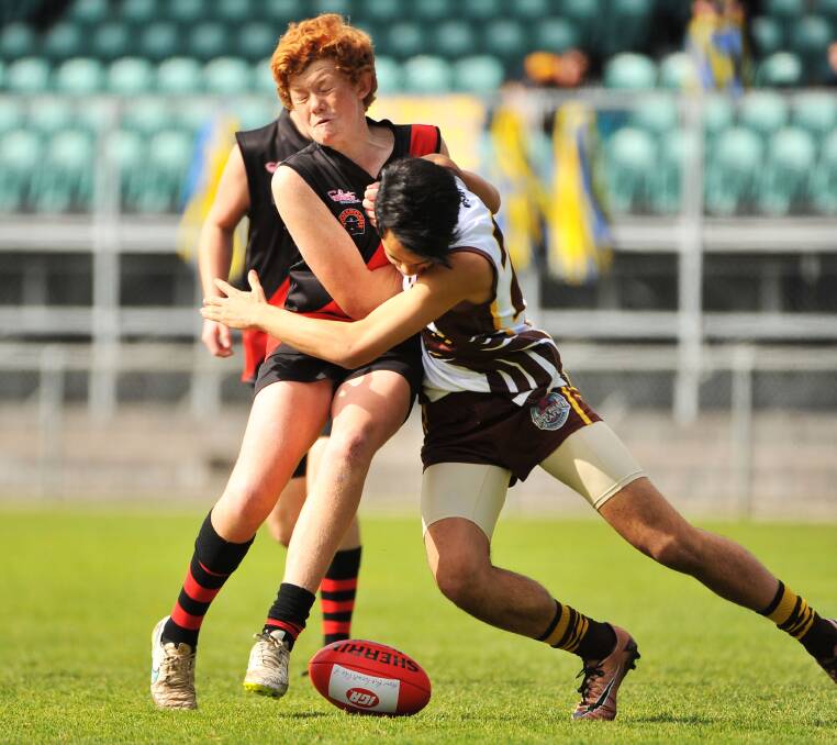 UNDER-14: North Launceston's Henry Hodgetts finds himself crunched by Prospect's Marcus O'Keefe in the Hawks' grand final win. Picture: Scott Gelston