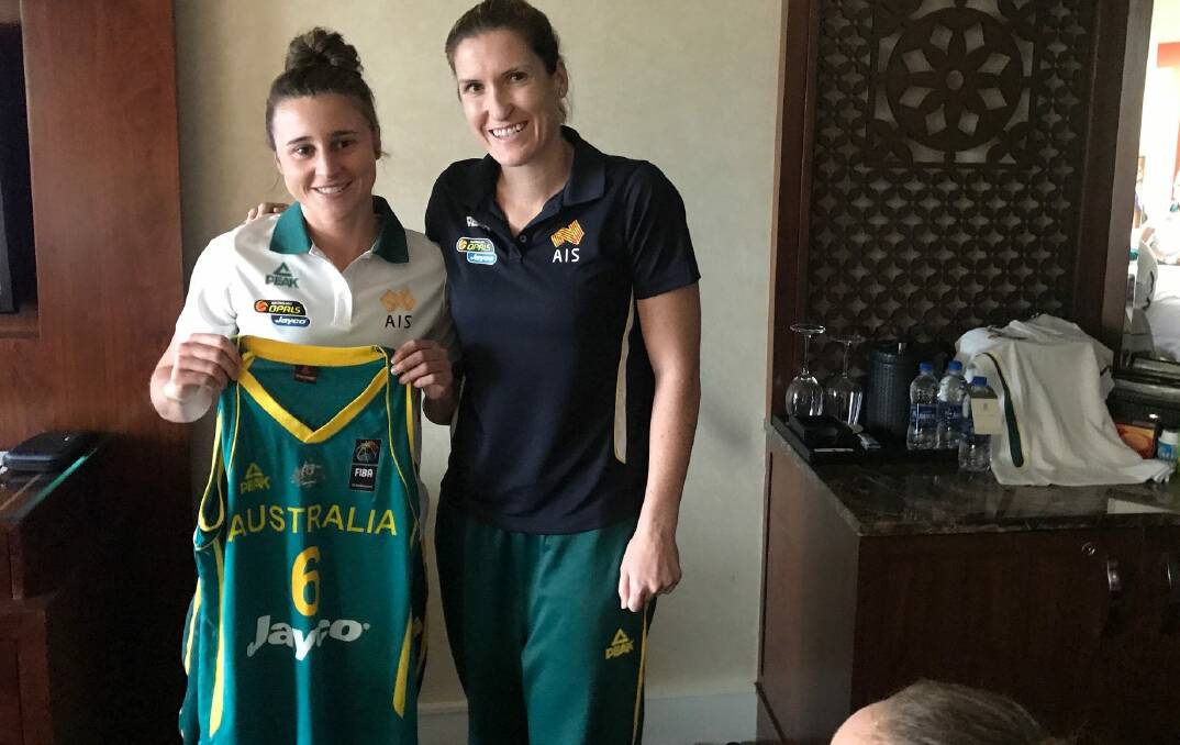 IT'S YOURS: Three-time Olympian Belinda Snell presents Launceston captain Lauren Mansfield a first Australian Opals singlet in her Bangalore room ahead of South Korea. 