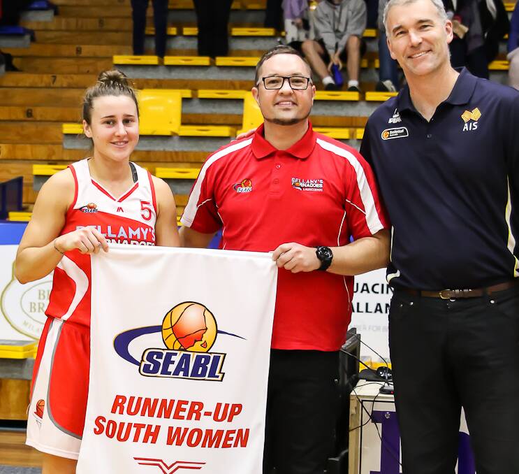 ALL SMILES: Coach Richard Dickel holds up the club's pennant with captain Lauren Mansfield in its last game of the year at the south conference final. 
