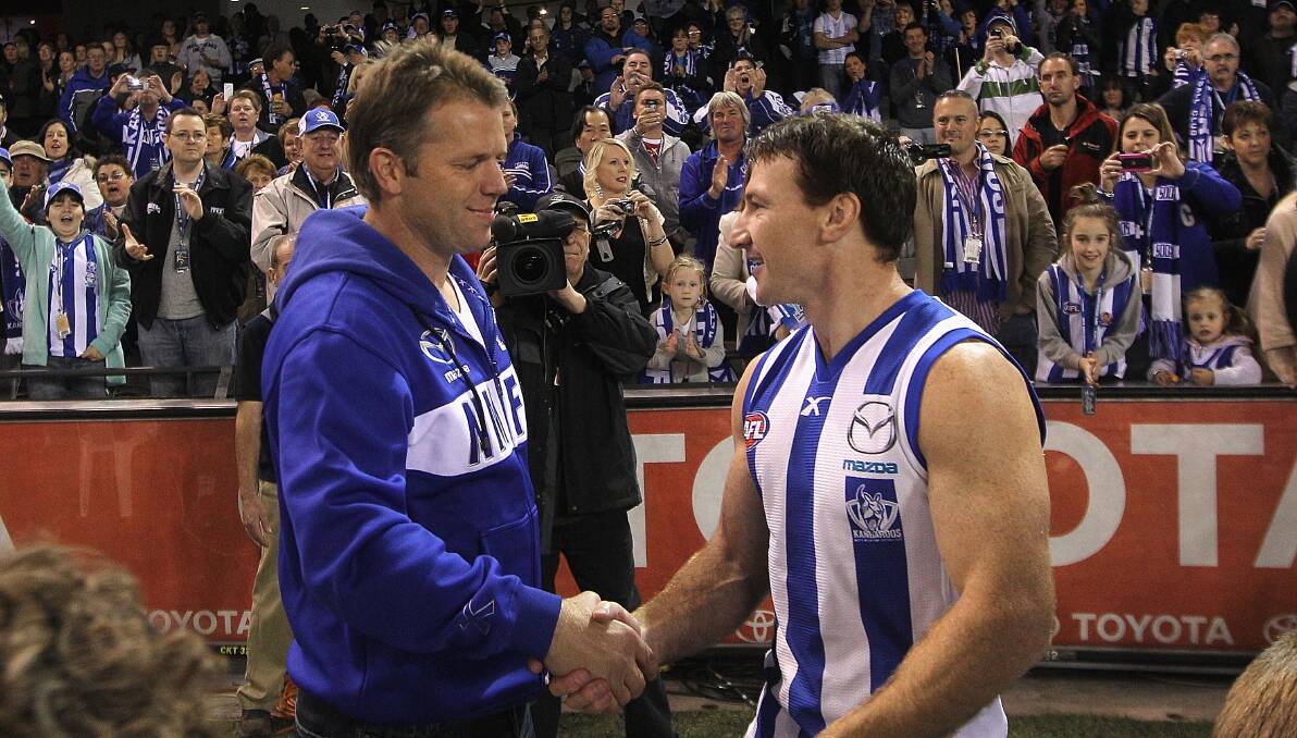 HANDS TO HANDS: Former North Melbourne champions Glenn Archer and Brent Harvey will take the field one more time during Ricky's Biggest Game of Cricket on Friday night. Picture: Getty Images