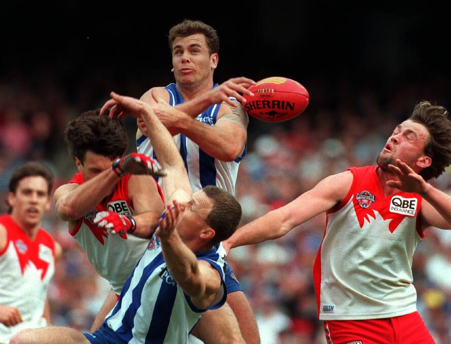 LEAPING ROO: Wayne Carey in full flight for North Melbourne over Paul Roos during the 1996 AFL grand final against Sydney. Picture: Fairfax Media