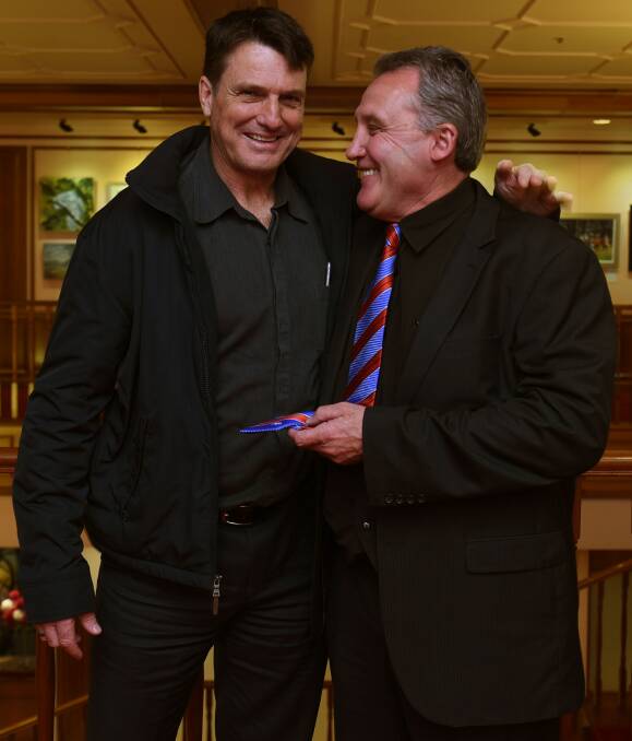 OLD MATES: AFL greats Paul Roos and Doug Hawkins share a laugh at Launceston's Country Club on Friday.