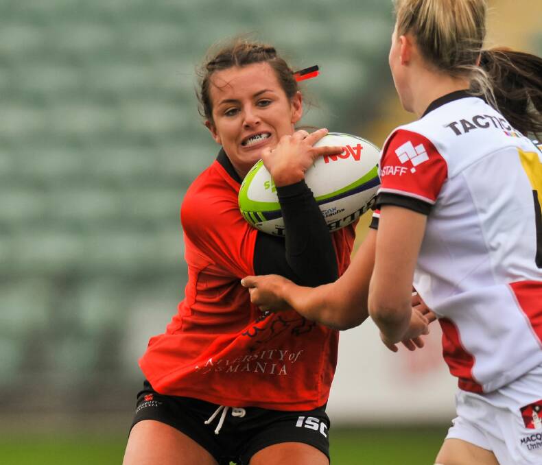 ON THE BURST: UTAS Lions star Lauren Murty looks to break out of a tackle on Friday against Macquarie University at Launceston. Picture: Phillip Biggs