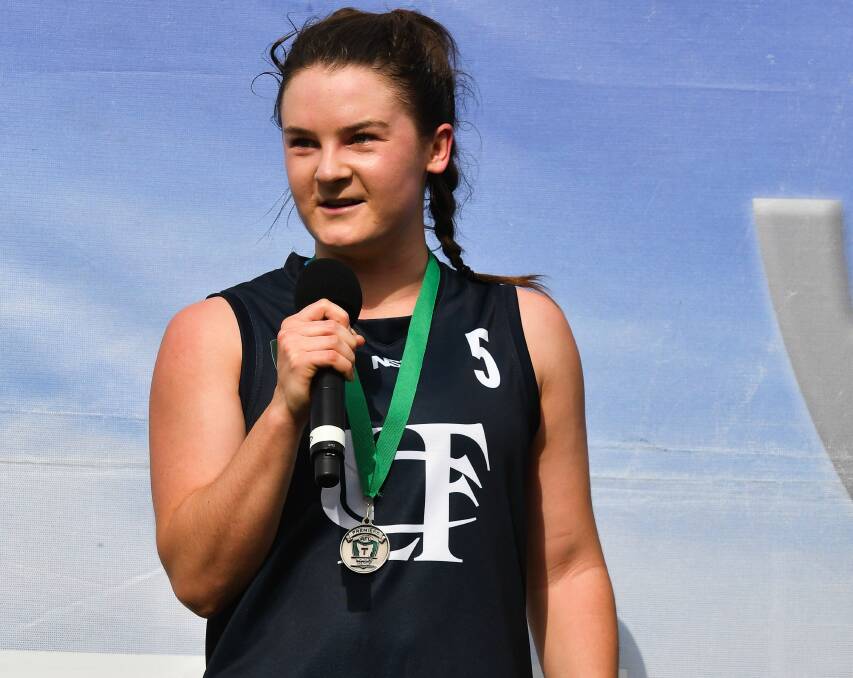 WINNER: Blues hero Courtney Webb stands on the podium on receiving her best-on-ground medal from the TSLW grand final at UTAS Stadium.