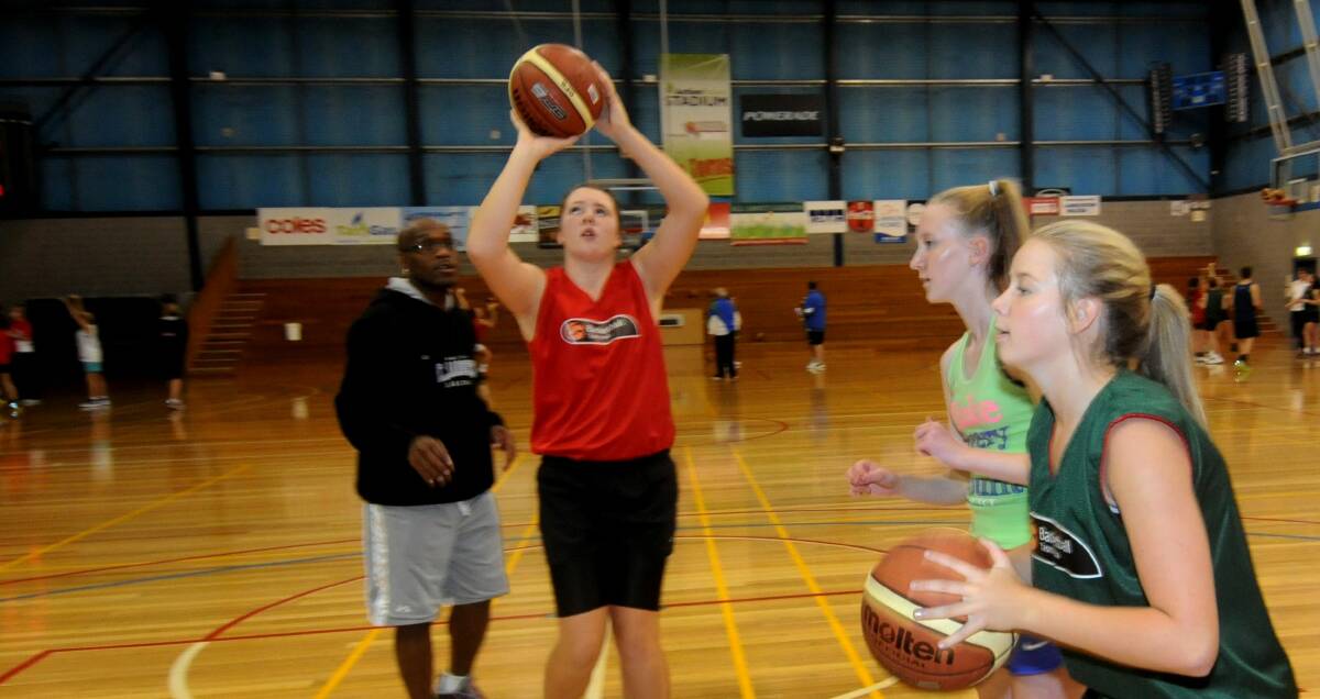 EYES UP: Brazendale practices her free throw under the watchful coaching staff at Basketball Tasmania.