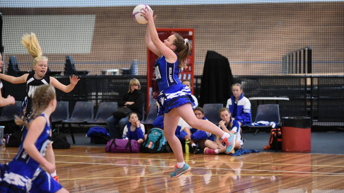 FLYING UP: Northern Midlands West wing attack Madeline Leonard at full stretch.