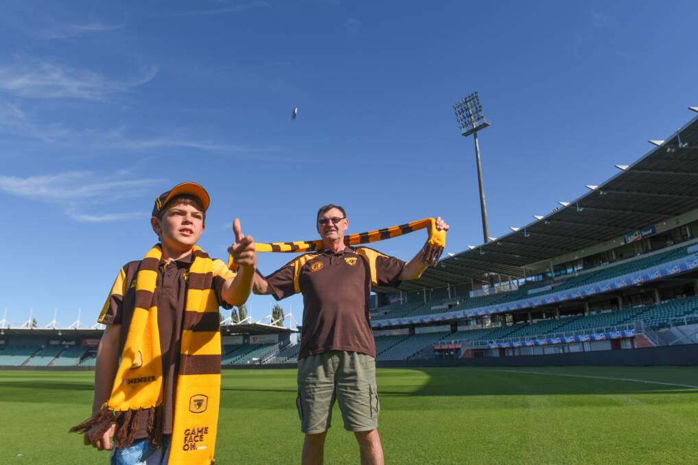 Heads or tails: Ryan Hayward and his grandfather Ken Hayward practising to flip the coin at the Hawks game on Saturday. Picture: Paul Scambler