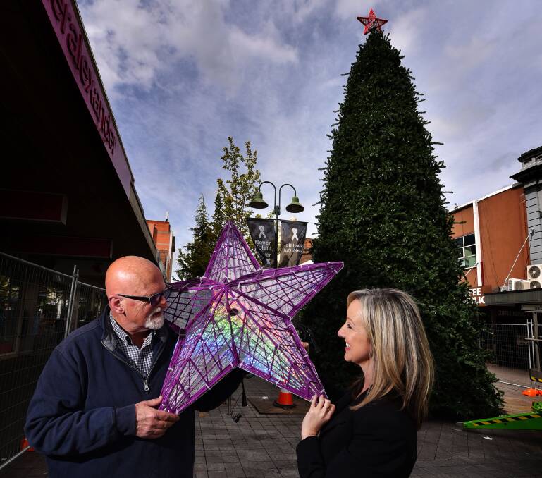 Christmas cheer: Colin Kent from Christmas Design Solutions and Cityprom executive director Vanessa Cahoon inspect one of the new star decorations in Brisbane Street Mall. Picture: Scott Gelston