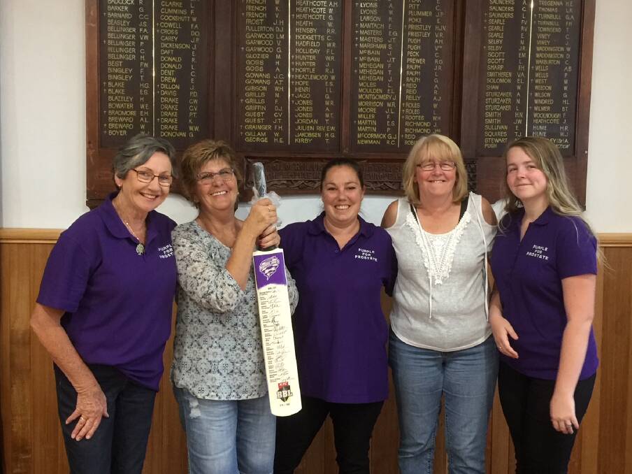 PURPLE: Anne Sackley, Gay Hall, Jordie Garven, Katrina Winzar and Maddison Winzar-Sutton. Ms Hall is holding a bat signed by the Hobart Hurricanes 2017-18 team. It is up for auction on Sunday. Picture: Supplied