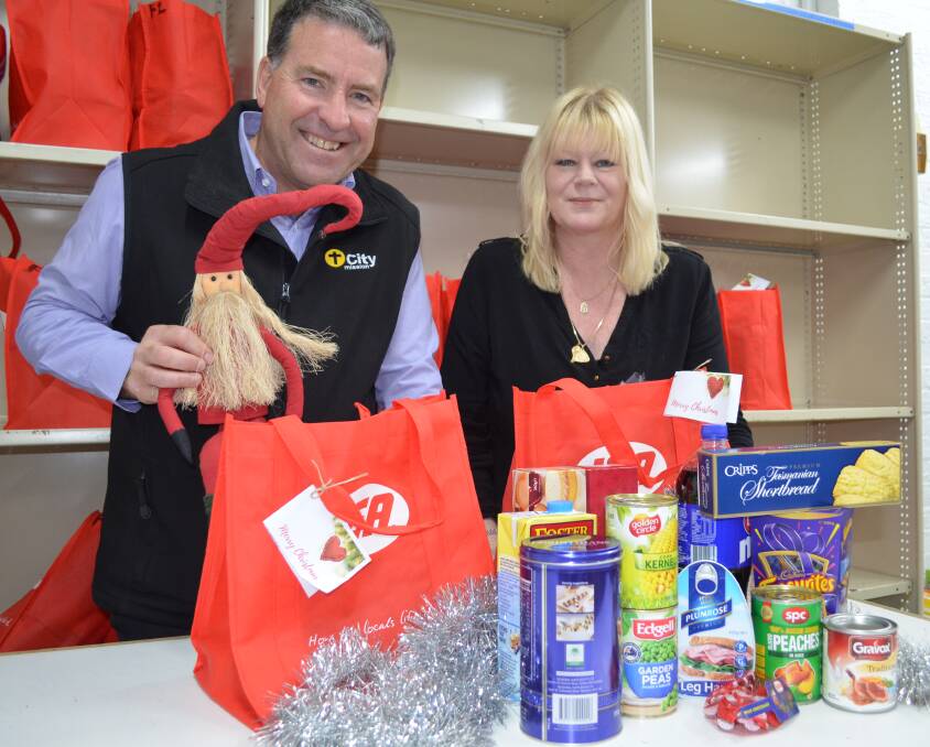 GIFT: City Mission chief executive officer Stephen Brown with Shelley Last, putting the finishing touches on this year's Christmas hampers. Picture: Jessica Willard. 