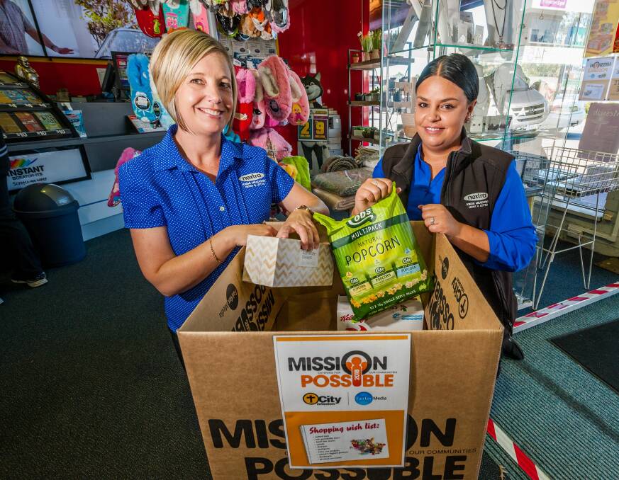 Kings Meadows Newsagency store assistants Natalie Kingshott and Kahli Weily, with the store's Mission Possible donation box. Picture: Phillip Biggs 