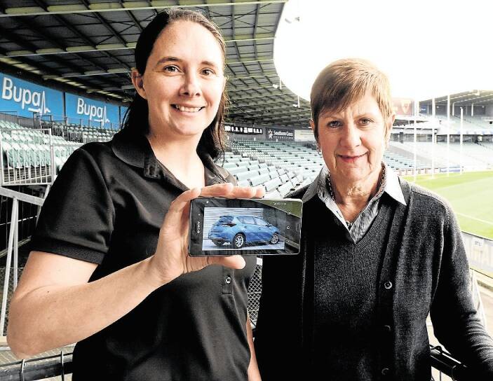 Tasmanian Eye Institute's Rachael Adams and Pam Preece show off a picture of the car to be raffled at the AFL clash on Saturday. Picture: NEIL RICHARDSON