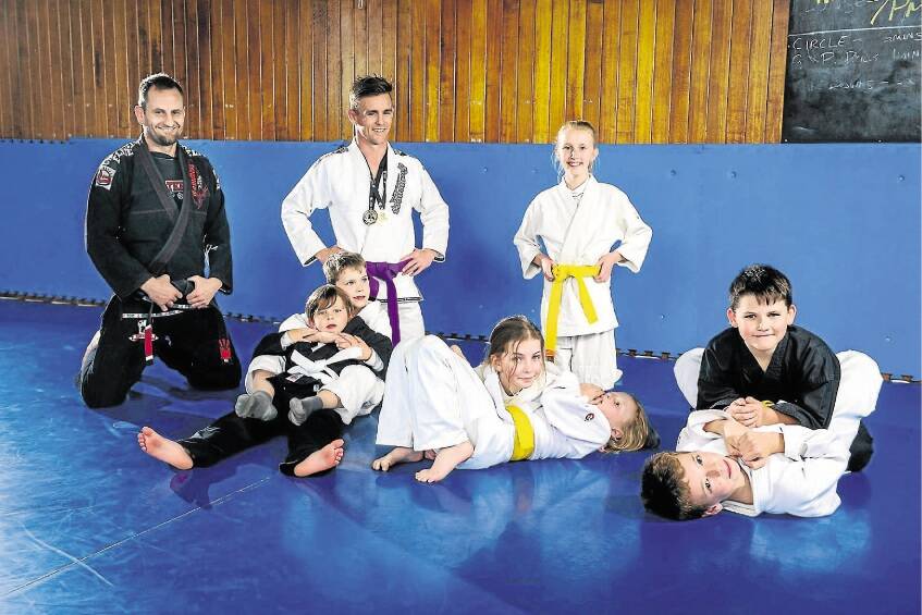 Brazilian jiu jitsu instructor Paul Butler and Machado Australasian Championship gold medallist Richard Graham with Lilly Brumby and, in front, Connor Graham, Charlie Casboult, Rita Young, Teagan Hodgetts, Blake Hodgetts and Jacoby Casboult. Picture: PHILLIP BIGGS
