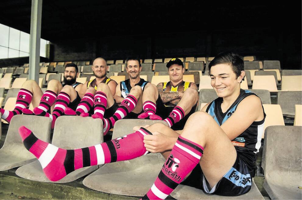 Perth's Jordan Furley tries on his pink socks ahead of Saturday's pink socks fundraiser day watched by Perth coach Damien Rhind, Prospect Hawks assistant coach Michael Sinclair, Perth captain Scott Furley and Prospect's Michael Murfet. Picture: PAUL SCAMBLER