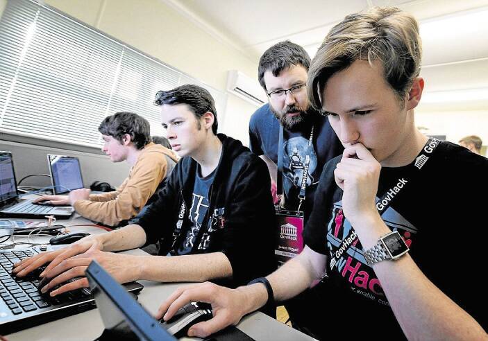 Keith Filgate, Harry Meskell and Nathaniel Bott  get a helping hand from Bitlink's James Riggall at GovHack. Picture: Geoff Robson.