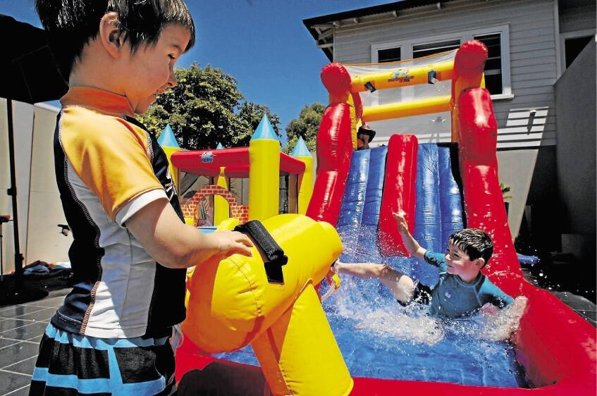 Fionn Creswell, 4, of East Launceston, fires the water cannon at brother Mani, 6, as neighbour Baylin Pease, 4½, waits his turn. Picture: PETER SANDERS