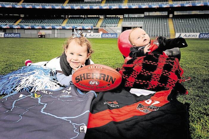 Jamison Griffiths, the two-year-old sister of Western Storm captain Jay Blackberry, and eight-week-old Boyd Littlejohn, son of Bombers captain Zane Littlejohn, have footy in their blood. Picture: SCOTT GELSTON
