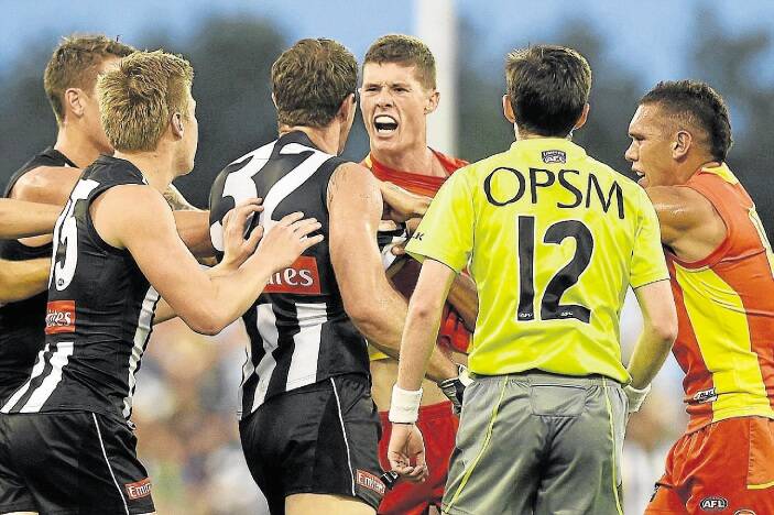 GOLD COAST, AUSTRALIA - MAY 23:  Henry Schade of the Suns and Travis Cloke of the Magpies wrestle during the round eight AFL match between the Gold Coast Suns and the Collingwood Magpies at Metricon Stadium on May 23, 2015 in Gold Coast, Australia.  (Photo by Matt Roberts/Getty Images)