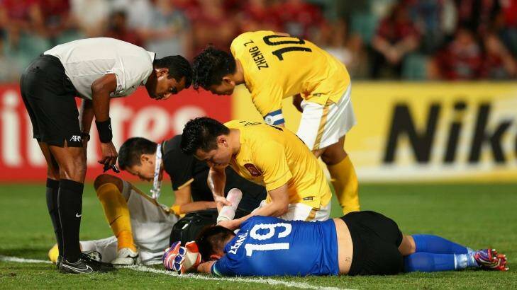Zeng Cheng of Guangzhou receives attention during the Asian Champions League match between the Western Sydney Wanderers and Guangzhou Evergrande  Photo: Cameron Spencer