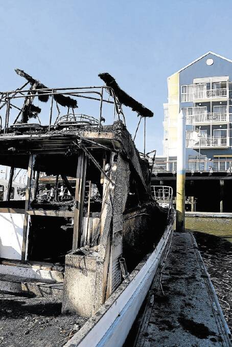 The burnt out remains of a vessel at the Seaport. The boat's owner was yesterday too upset to return to the fire scene. Picture: MARK JESSER