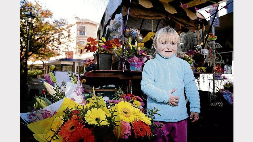 Meila Wigg, 3, of Deloraine, looks at some flowers in the Quadrant Mall. Picture: SCOTT GELSTON