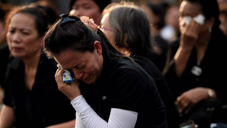Women dressed in black weep outside the Grand Palace in Bangkok. Photo: Kate Geraghty
