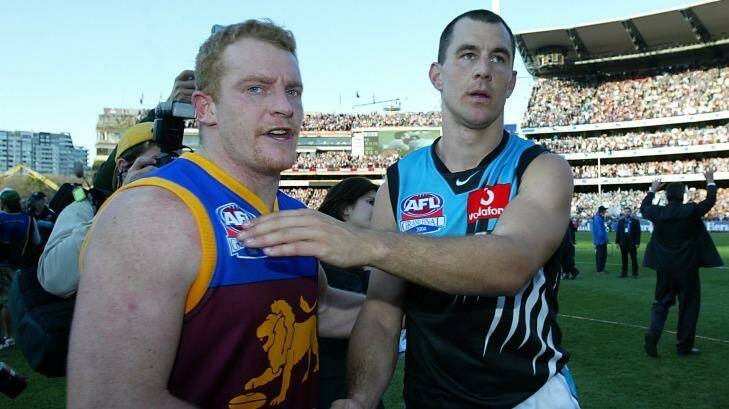 Michael Voss shakes hands with Port Adelaide stalwart Warren Tredrea after the 2004 grand final. Photo: Ray Kennedy