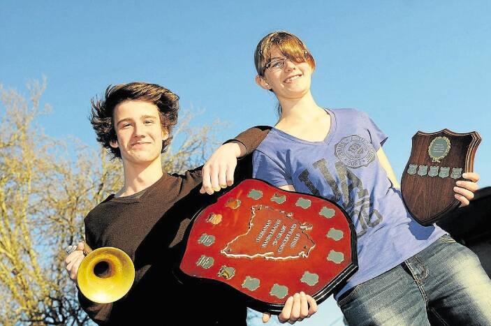 Launceston College students Darcy O'Malley, 16, and Jess Walsh, 18, hold the D-grade concert band and junior C-grade concert band trophies. Picture: PAUL SCAMBLER
