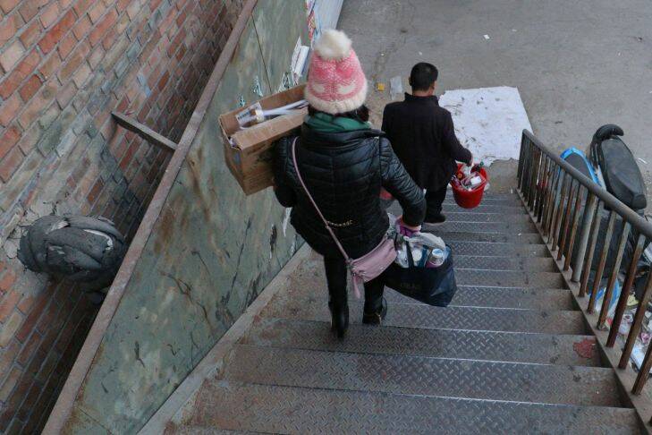 Yan Erjun, 50, a migrant construction worker from Sichuan Province and his wife Zhou Xiaomei, 44, a house cleaner moving their home by carrying bags on his shoulders at Picun Village in Chaoyang District of Beijing on November 27, 2017. Yan and his wife were given a very short notice to move out from their rented apartment in which power supply was cut off. A notice on the midday of November 27 asks all apartments for rent in the village should be cleared off by 6:00PM of the same day. Later the day, the deadline was postponed to December 1, 2017. Picun Village, in the eastern outskirt of Beijing is home some 20,000 migrant workers as it affords relatively cheap accommodation(from 500-1,000rmb/m). Beijing municipality government has launched a 40-day check and rectification of hidden dangers after a fire in Daxing District of Beijing on November 18 claimed 19lives. The municipalty has been criticized of driving out "low-end" population which Beijing Administration of Work Safety denied on Sunday(November 26). .