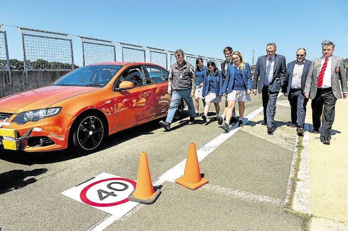 Driving instructor Tony Oliver steps out the stopping distance for a car travelling at 40km/h with Launceston Church Grammar School students Cinny Shek, Momoka Makayama, Joe Crawford, Chelsea Mawer, Infrastructure Minister Rene Hiding, RACT CEO Harvey Lennon and Rotary Tasmania district governor Ken Moore. Picture: PHILLIP BIGGS
