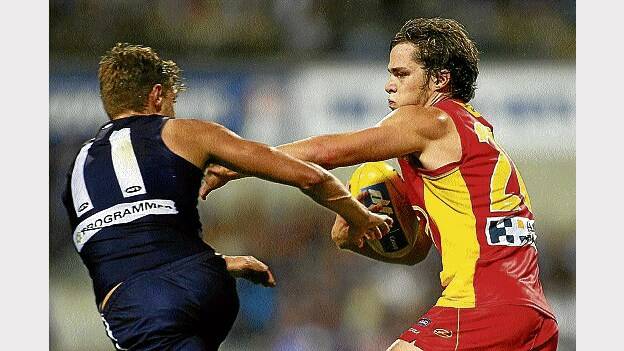 Gold Coast's Kade Kolodjashnij fends off a tackle by Docker Thomas Sheridan during their round 2 AFL clash at Patersons Stadium. Picture: GETTY IMAGES