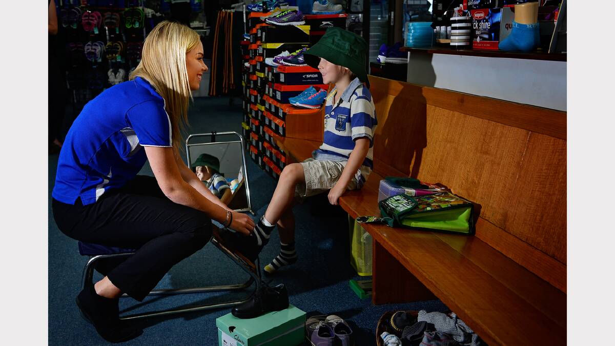 Targetts sales assistant Abbie Donnelly helps David Golledge, 6, with new shoes as he is going into year 1 at Launceston Christian School. Picture: Phillip Biggs