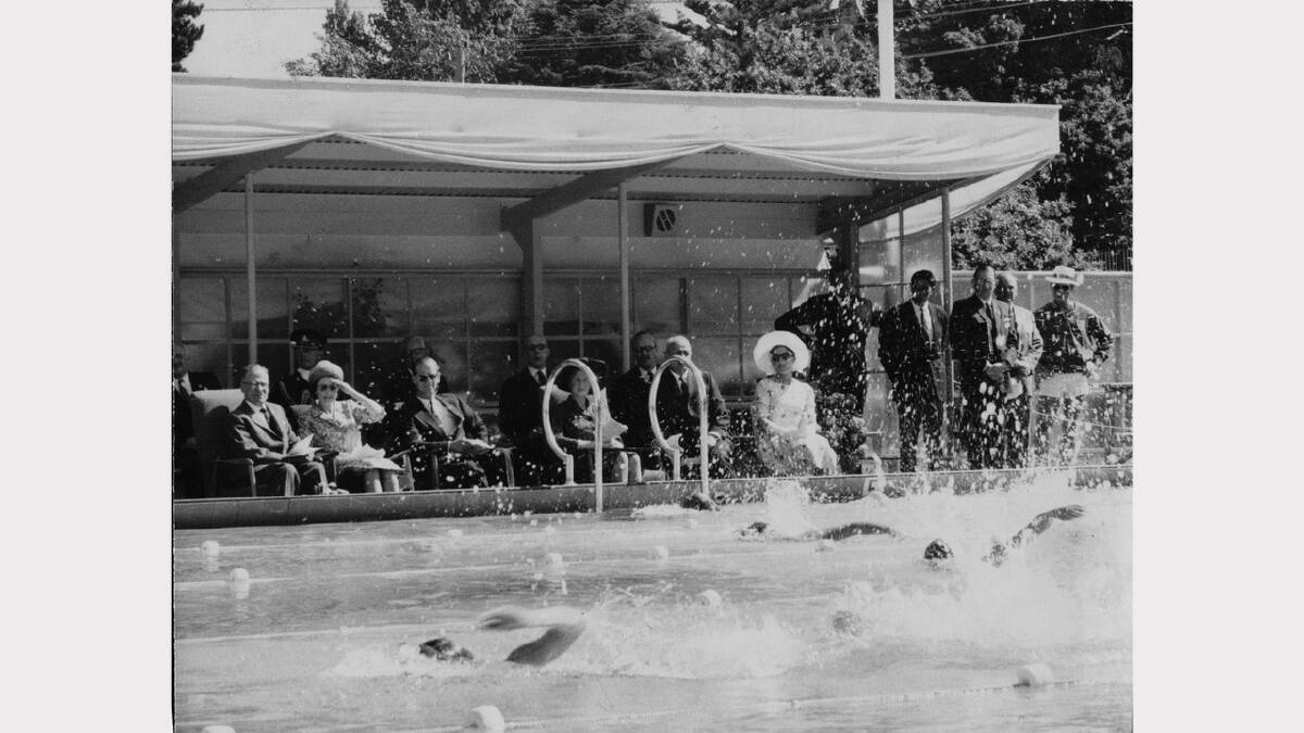 Queen Elizabeth and Prince Philip's 1963 royal visit | The Royal couple watchin swimming events at the Hobart Olympic pool. The Queen is shading her eyes from the glare and is wearing sunglasses.