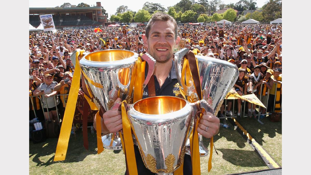 Hawks captain Luke Hodge poses with the 2013, 2014 and 2015 premiership trophies during the Hawthorn Hawks AFL Grand Final fan day at Glenferrie Oval. The Hawks will visit Launceston on Wednesday. Picture: GETTY IMAGES