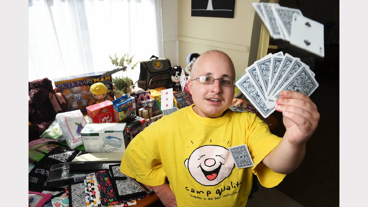 Heath Millhouse, of Norwood, holds a hand of cards to be used in the fundraising event for Camp Quality. Picture: MARK JESSER