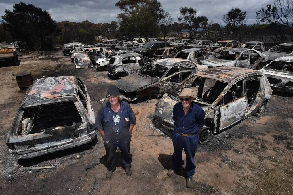 Michael Baker, from the George Town wrecking yard, speaks to reporter Michelle Wisbey and photographer Scott Gelston about the impact the bushfire had on his business. He estimated between 200 and 300 cars were burnt in the fire - about half of his stock. Michael is pictured with his dad, Patty. Picture: SCOTT GELSTON