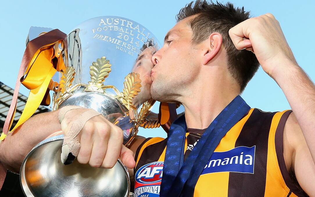 Winning Hawthorn captain and second-time Norm Smith medallist Luke Hodge delivers his second major kiss of grand final day. Picture: Getty Images