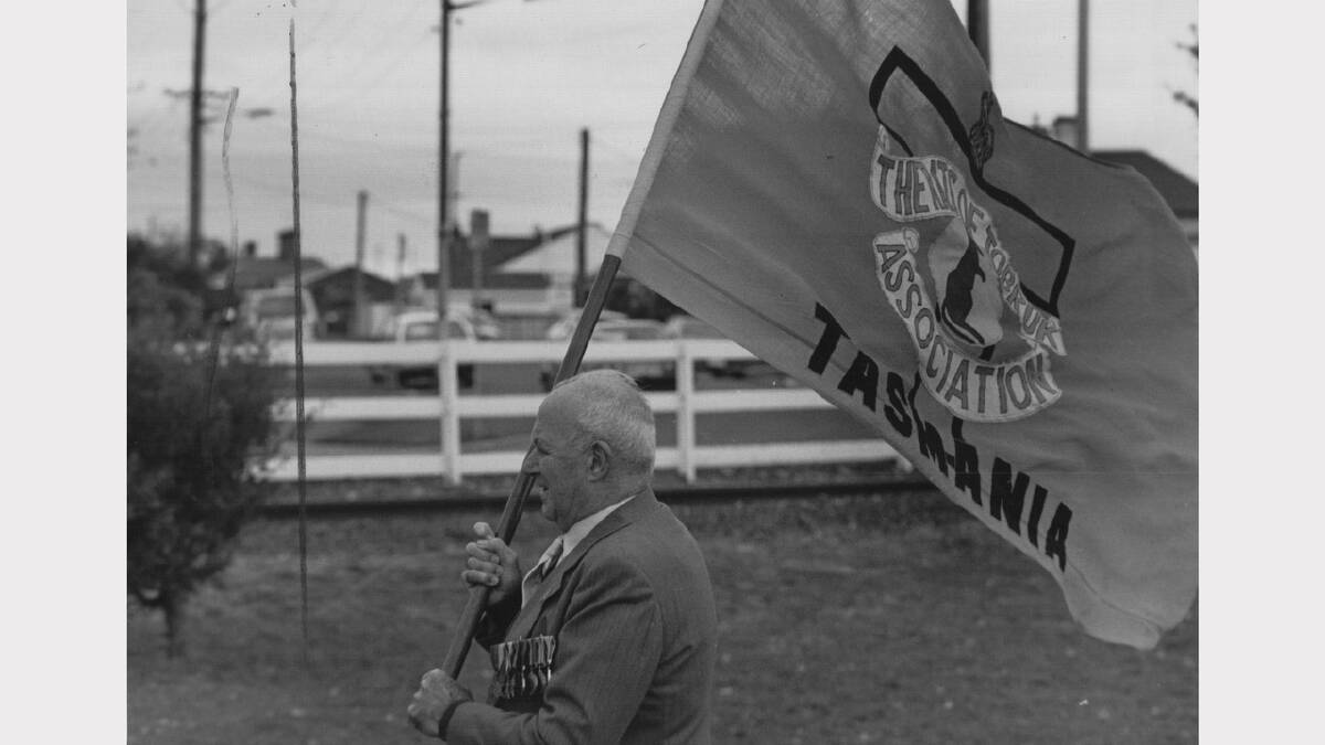 Anzac Day flashback gallery | Lou Lawler carries the Rats of Tobruk flag in Devonport, 1991.