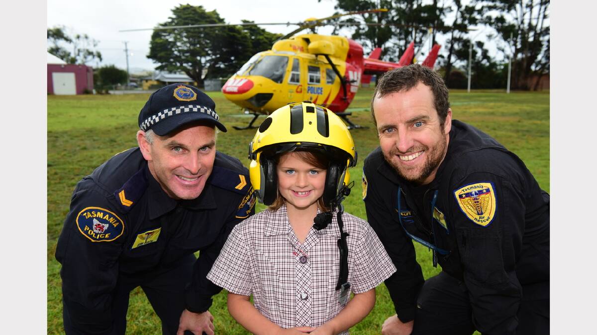 Senior Constable Josh Peach, Star of the Sea pupil Daisy Lindfors, 8, and rescue helicopter pilot Chris Fahey at George Town. Picture: Paul Scambler
