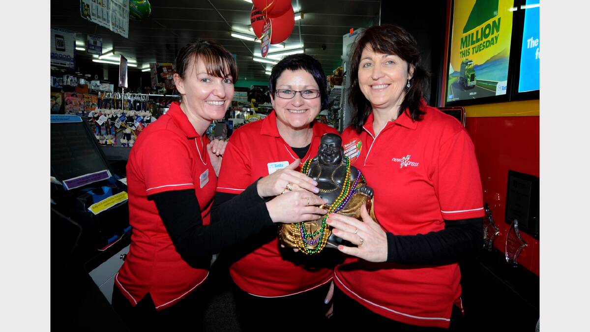 NewsXpress George Town award win is celebrated by Danielle Walsh, Julie Lynch and owner Sue Sherriff with their lucky Buddha.  Picture: GEOFF ROBSON