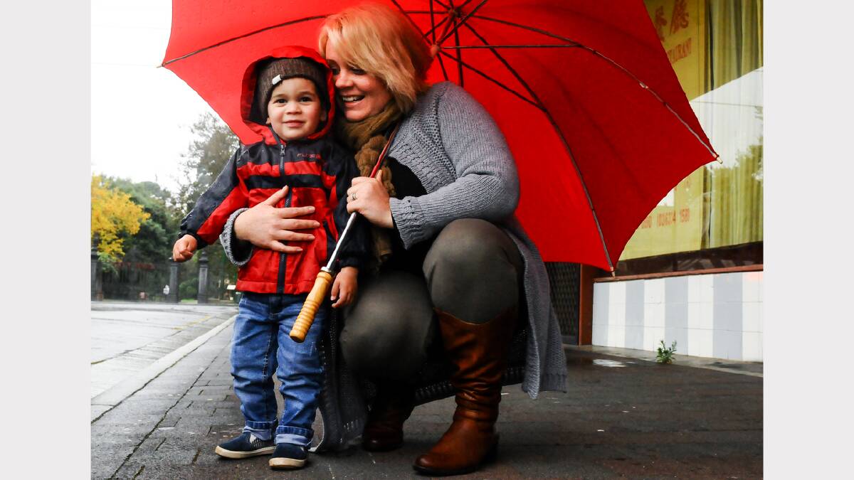 Stephanie Mason, of Hobart, with son Oliver, 2, brave the weather in Launceston yesterday. Picture: NEIL RICHARDSON